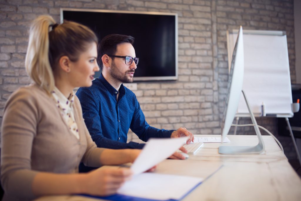 Two professionals collaborating on business consultancy services in Dubai, discussing strategies in a modern office setting.